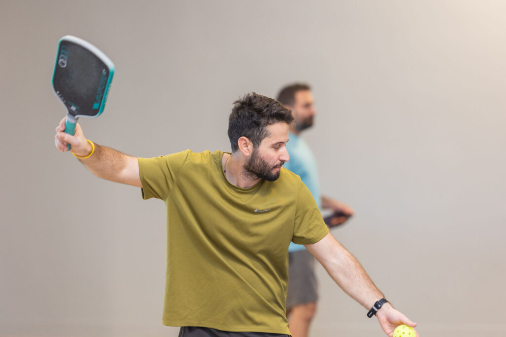 Player hitting a forehand during a pickleball game at JEM PicklePlace