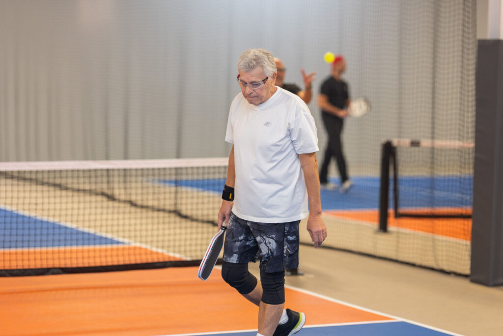 Members playing pickleball on an indoor court at JEM PicklePlace