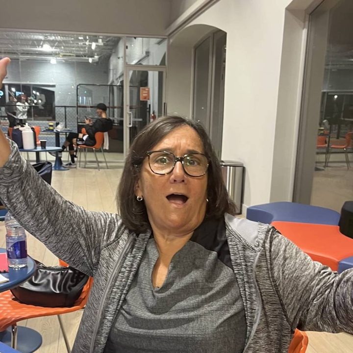 A JEM member with her arm in the air, surprised she just won
